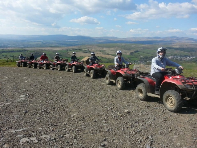  personas con cascos blancos y sonriendo mientras conducen rojo quads