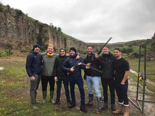  Groupe d'amis portant des vestes noires et grises, souriant et faisant du tir au pigeon