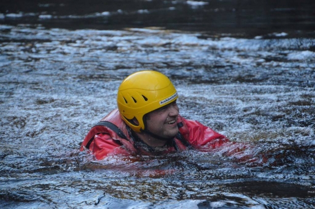 Homme souriant et portant un casque jaune en canyoning