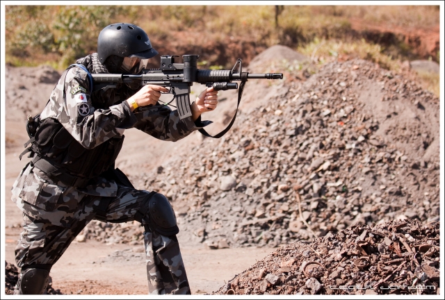 Boy wearing military suit playing paintball