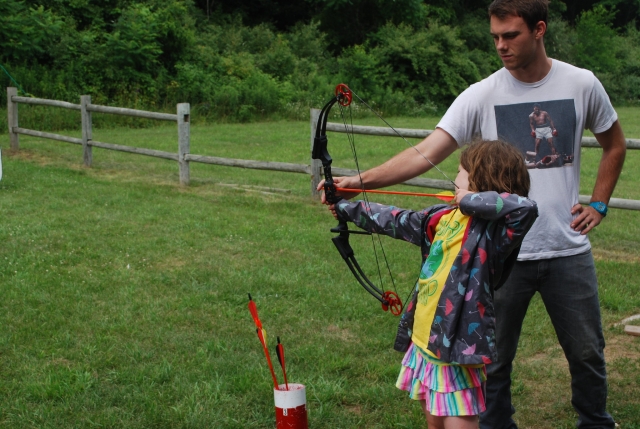 Little girl with instructor during her archery session