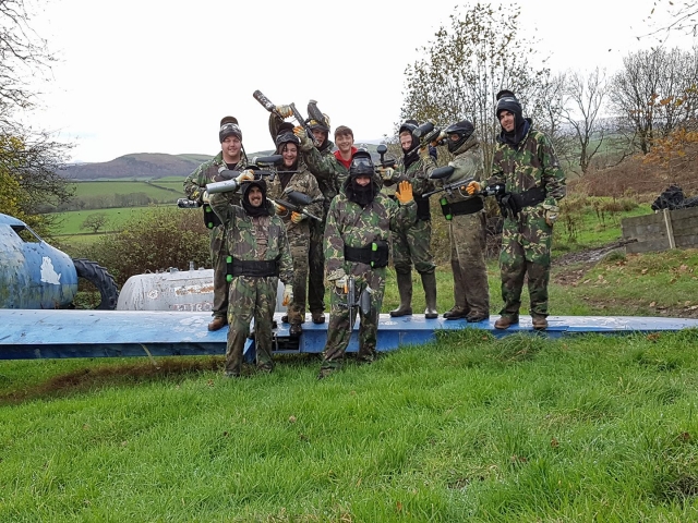 Group of friends wearing camouflage suit doing paintball