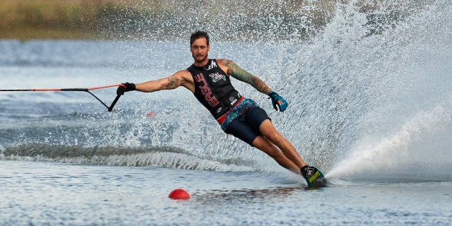 Man wearing black buoyancy aids water skiing 