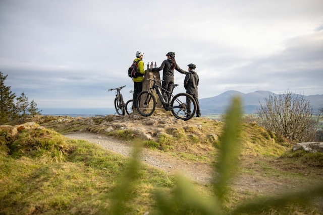  Famiglia che indossa caschi bianchi e neri che bevono durante la sessione in bicicletta 
