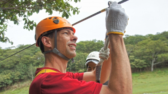  Homem usando lã de laranja e lã de lã de zip lining