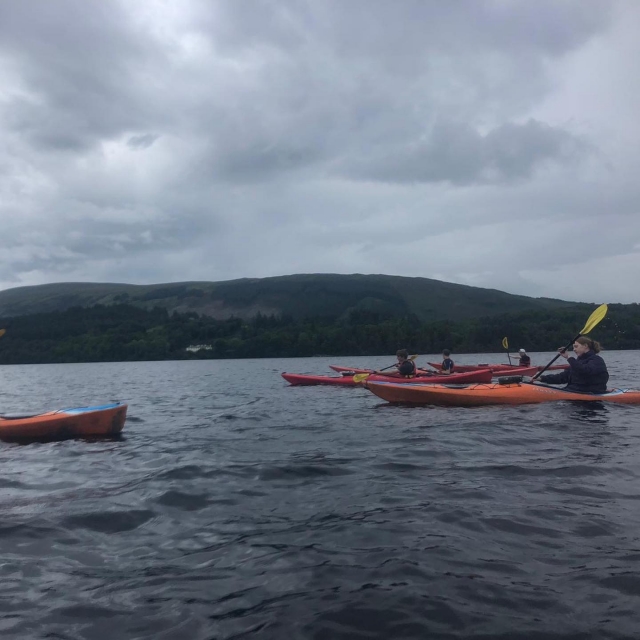  Persone che vanno in canoa intorno al lago e la montagna sullo sfondo 