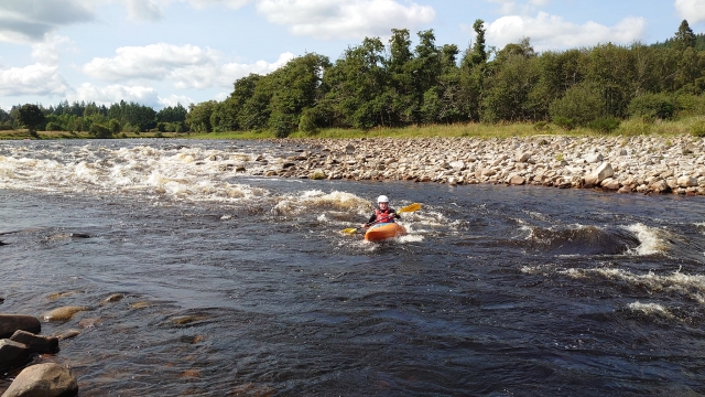  Ragazzo che fa kayak nel fiume mentre indossa un casco bianco e aiuti al galleggiamento rossi 