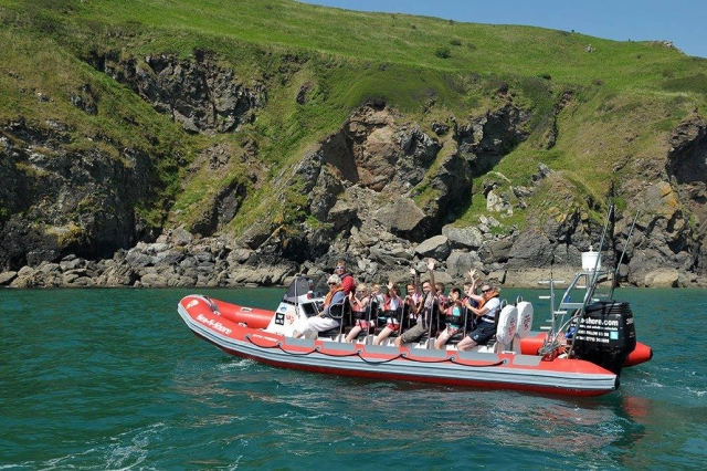 People wearing orange and red buoyancy aids during their boat trip
