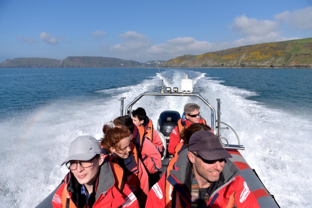 People wearing orange buoyancy aids during their boat trip