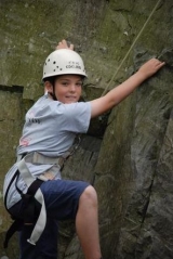 Climbing our rock wall in the forest