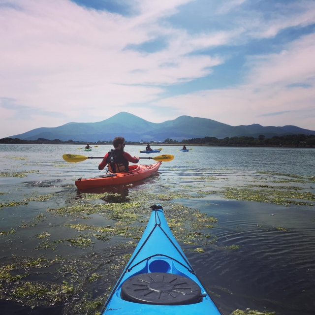  Persone che indossano mute rosse in canoa sul lago su canoe rosse e blu 