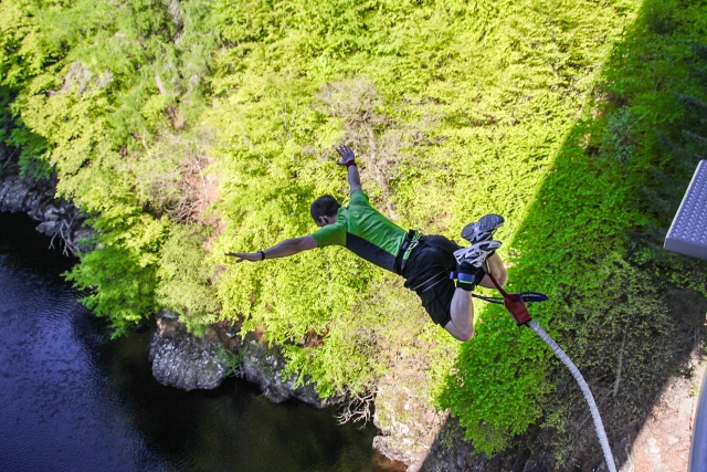 Homme portant un t-shirt vert pendant le saut à l'élastique