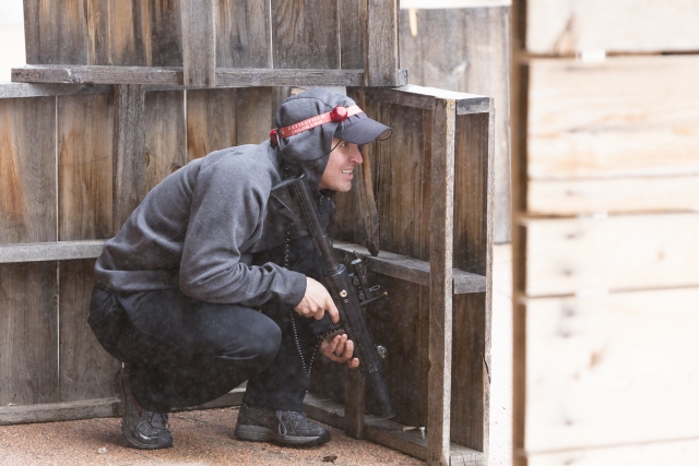  男人在玩激光标签时躲起来 