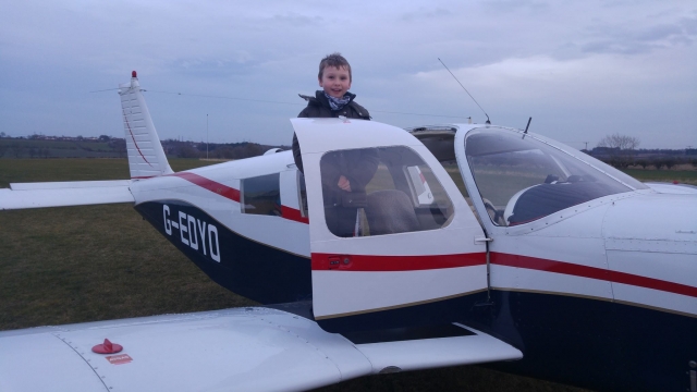  garoto em jaqueta prestes a pilotar um helicóptero branco 
