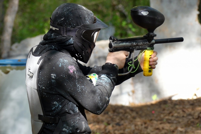  Garçon jouant au paintball portant un masque et un costume noirs 