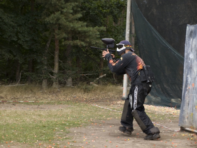  Garçon en costume noir jouant au paintball 