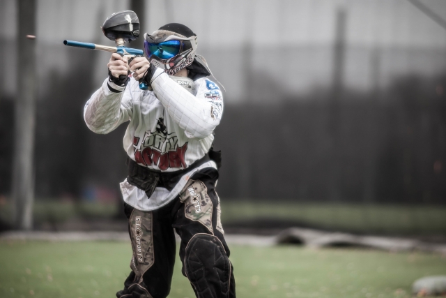  Uomo con un maglione bianco che spara mentre gioca a paintball 