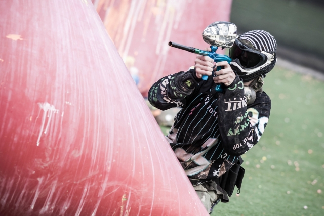  Uomo che indossa tuta da paintball, maschera e casco che spara 