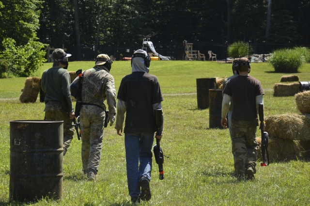  Groupe de personnes portant des costumes de camouflage tout en jouant au paintball 