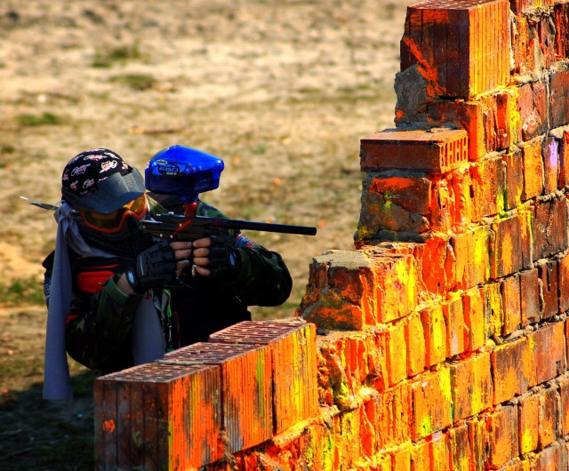  Uomo dietro un muro che gioca a paintball 