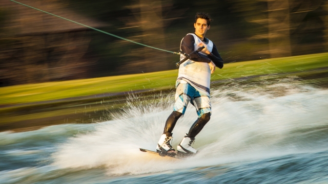  Junge im weißen Badeanzug beim Wakeboarden