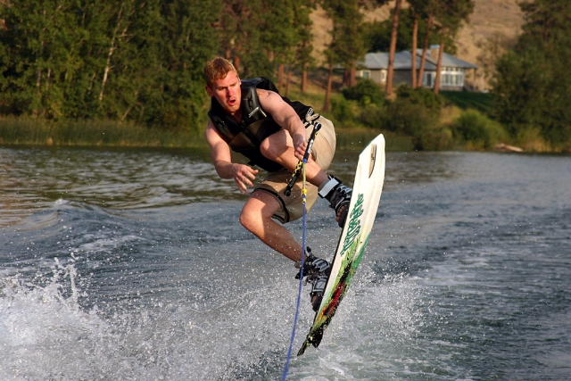  Mann in schwarzen Schwimmhilfen beim Wakeboarden 