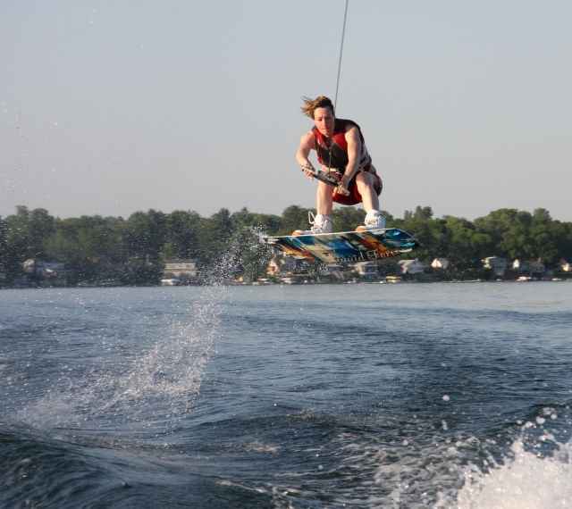  Mann in roten Schwimmhilfen beim Wakeboarden 