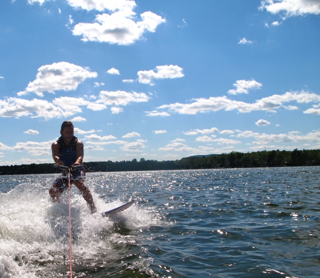  Junge in schwarz-blauen Schwimmhilfen beim Wakesurfen 