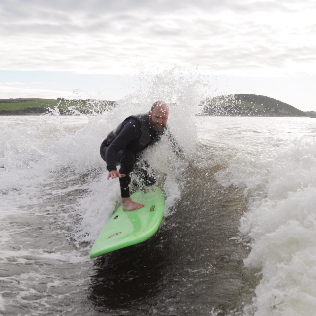  Mann beim Wakesurfen über grünem Surfboot