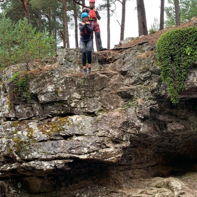 e-19759598-girl-wearing-blue-helmet-and-black-wetsuit-jumping-from-the-cliff-during-her-canyoning-session16433712243033.jpg