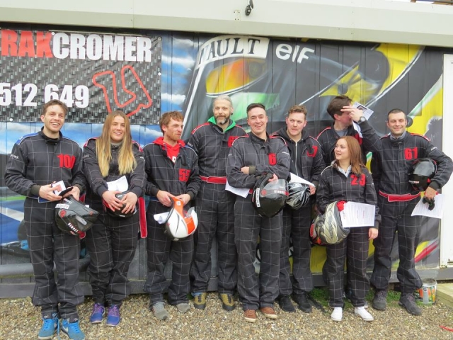 People getting ready for karting with us. They're wearing black driving suits