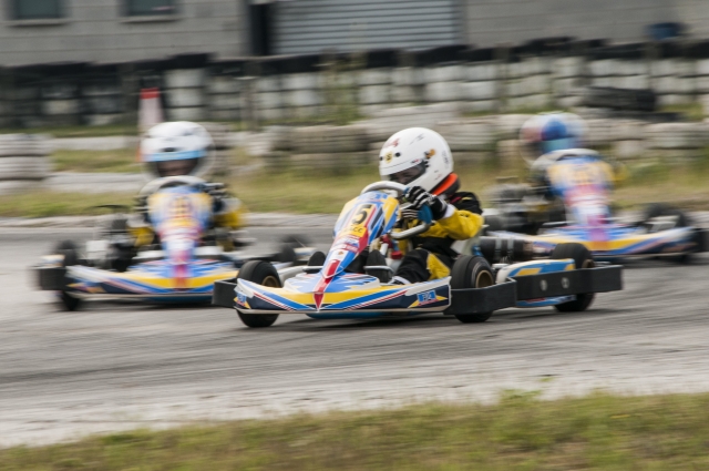  Pilote en combinaison bleue conduisant vite pendant la course de karting