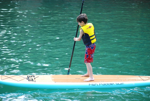  Garçon essayant le paddleboard pour la première fois 