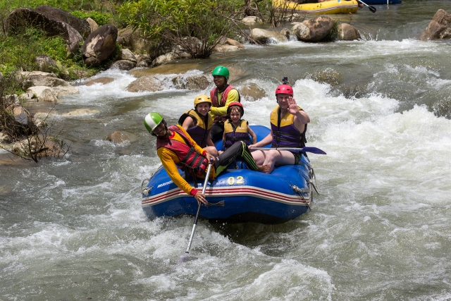  Una famiglia che indossa attrezzatura gialla e blu che fa rafting sul fiume Findhorn 