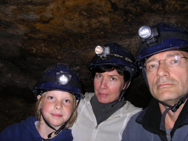 Family wearing blue helmets and comfortable clothes for caving