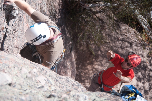 Man climbing with the help of instructor