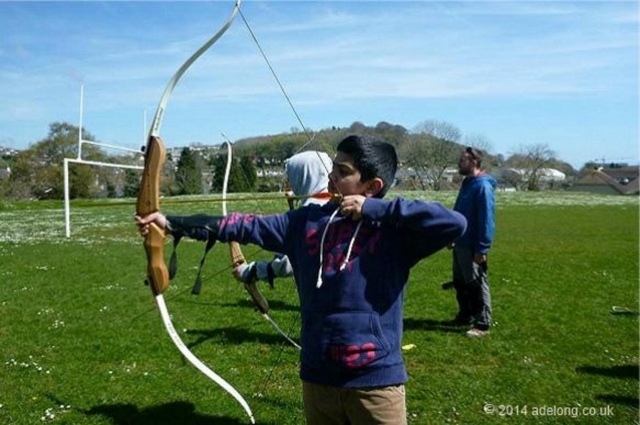 Niño con chaqueta azul probando tiro con arco en Devon 