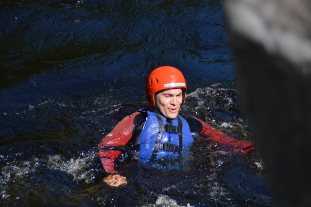 Man wearing blue buoyancy aids swimming during his canyoning experience