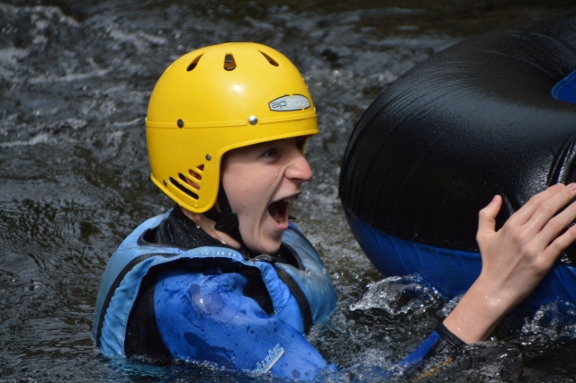 Boy wearing blue life jacket and yellow helmet during canyoning session