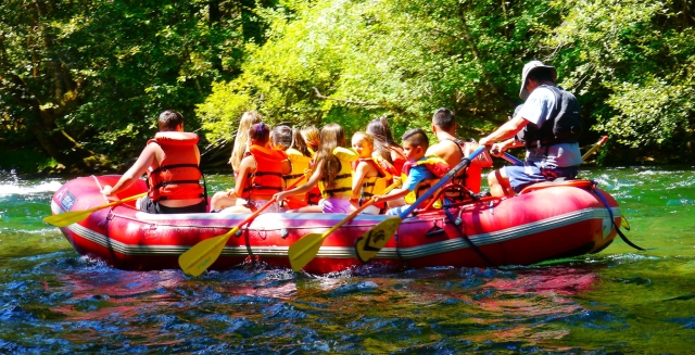 Group of children wearing red buoyancy aids canoeing