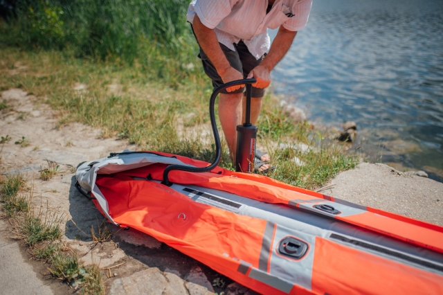  Uomo che gonfia un kayak rosso 