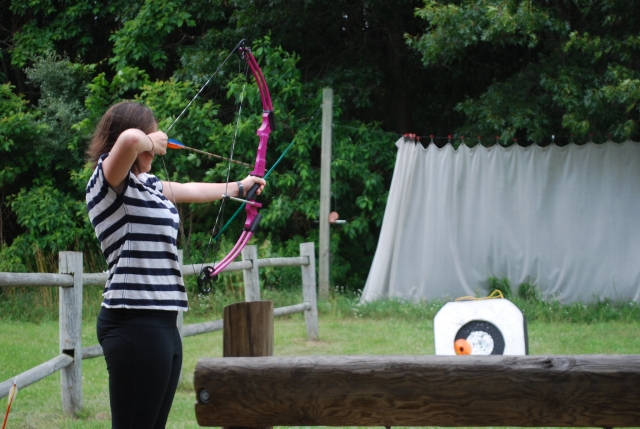  Mujer practicando tiro con arco durante su curso para principiantes 