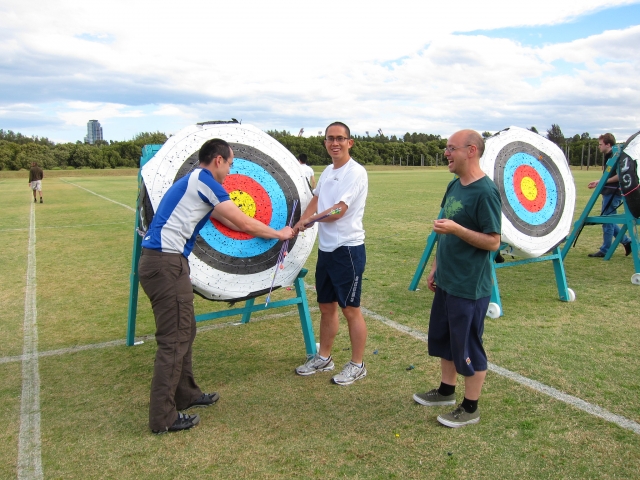  Grupo de hombres practicando tiro con arco como parte de su curso para principiantes