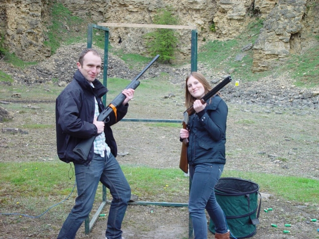 Girl and boy smiling holding the gun before their clay pigeon shooting session