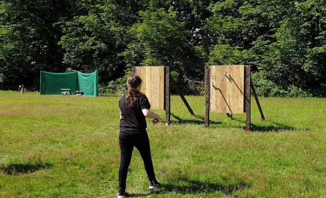 Young girl in black axe throwing