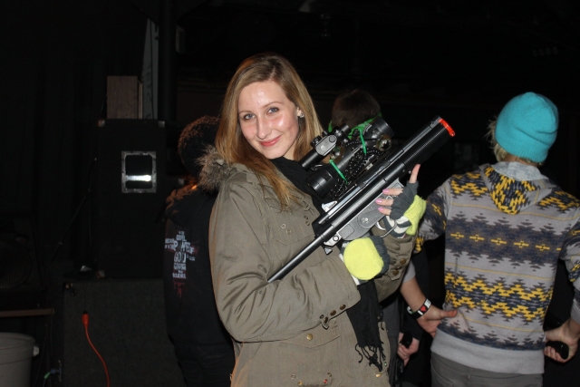  Fille souriante, portant une veste marron et se préparant pour sa séance de laser tag