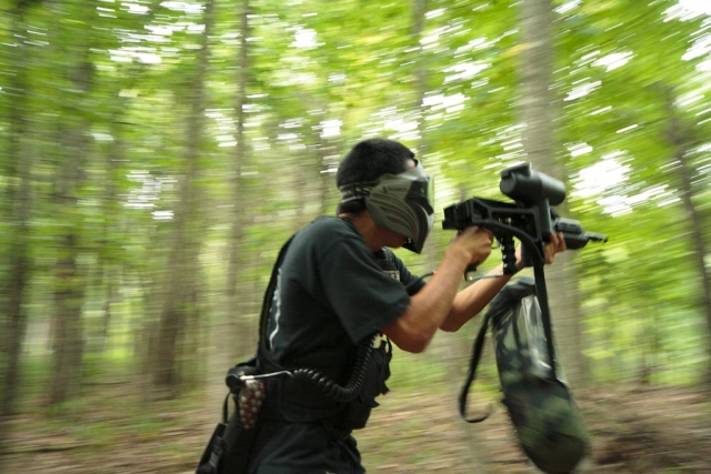  Garçon portant un t-shirt vert jouant au paintball