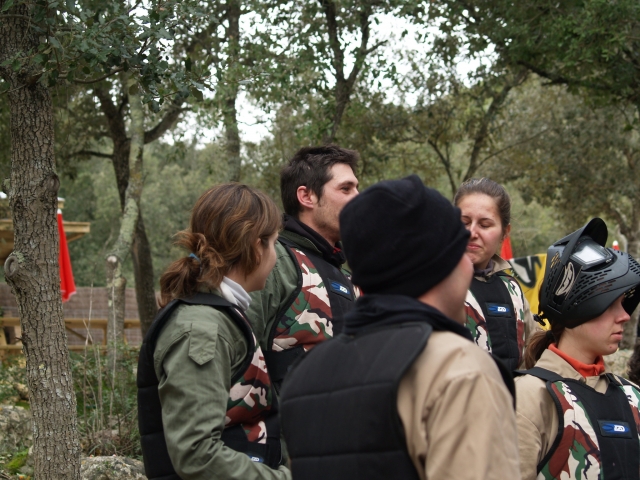  Groupe d'hommes et de femmes se préparant et portant des costumes verts avant de jouer au paintball 