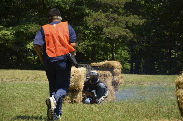  Garçon portant un équipement de protection orange courant vers le paintball 