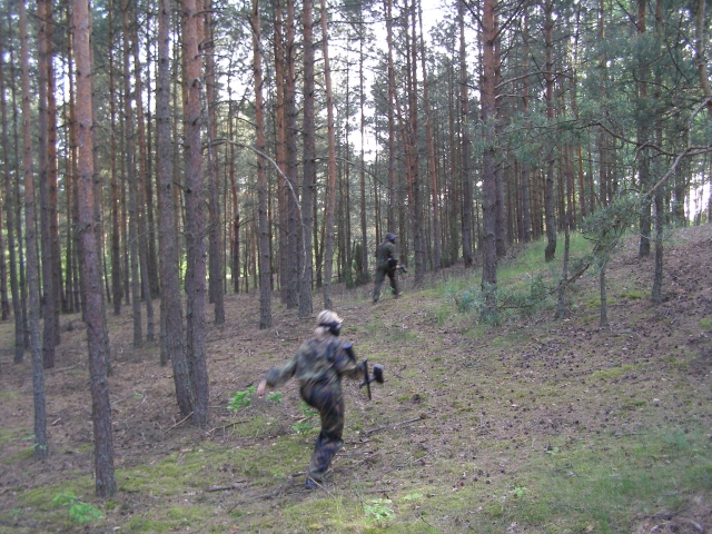  Donna che corre dietro a un uomo per sparargli mentre gioca a paintball 